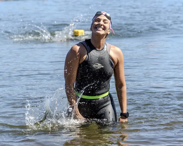 Atleta sai da água sorrindo após completar a travessia